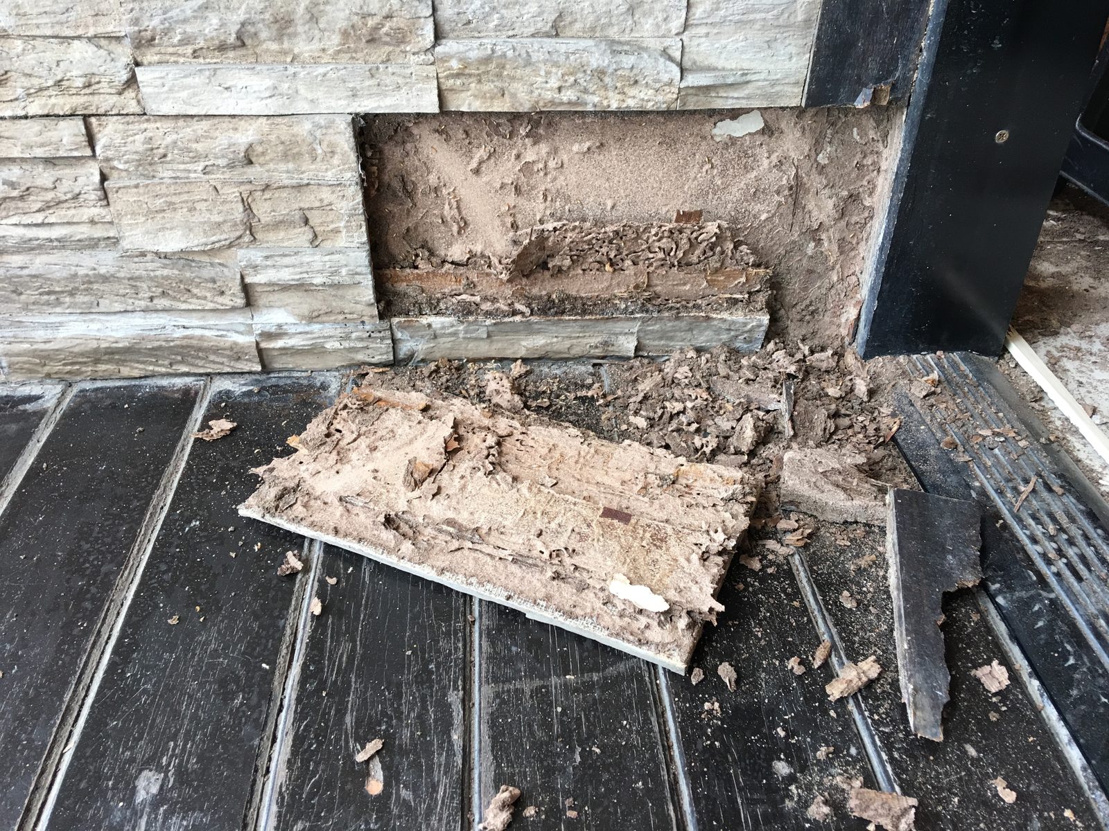 Water damage and wood rot at the base of an exterior wall
